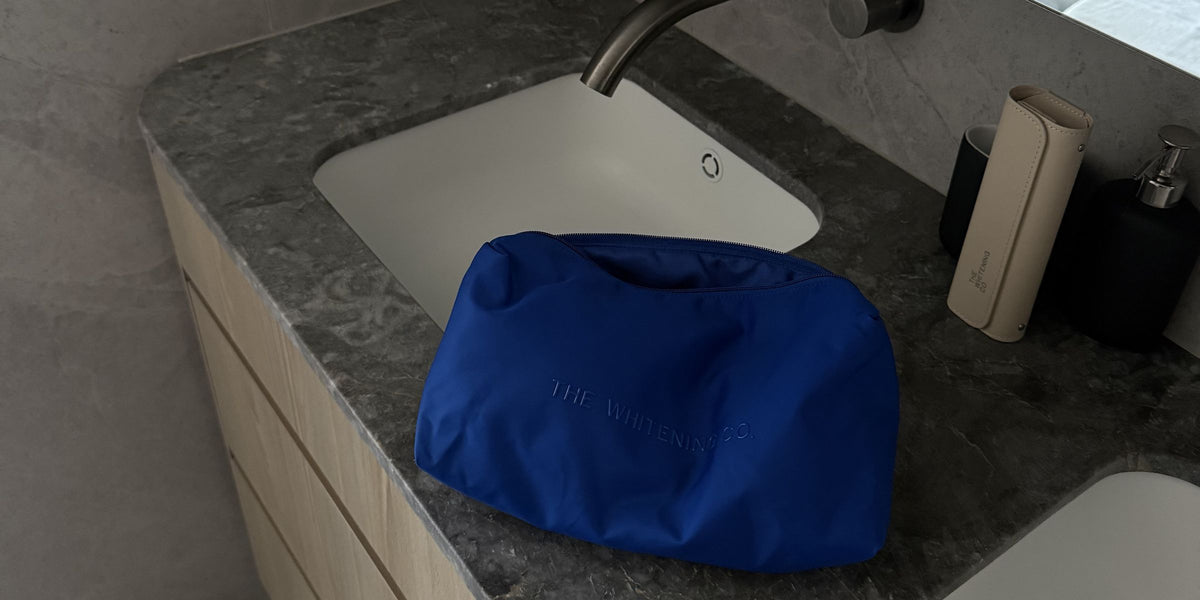 The Beauty Bag in Cobalt on a stone bathroom vanity
