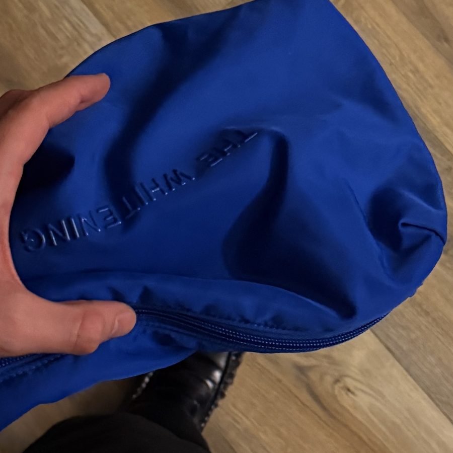 Soft, puffy nylon of the Cobalt Beauty Bag squeezed in one hand
