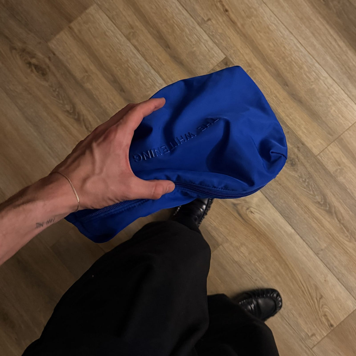 The Beauty Bag in Cobalt held in one hand, soft and squishy