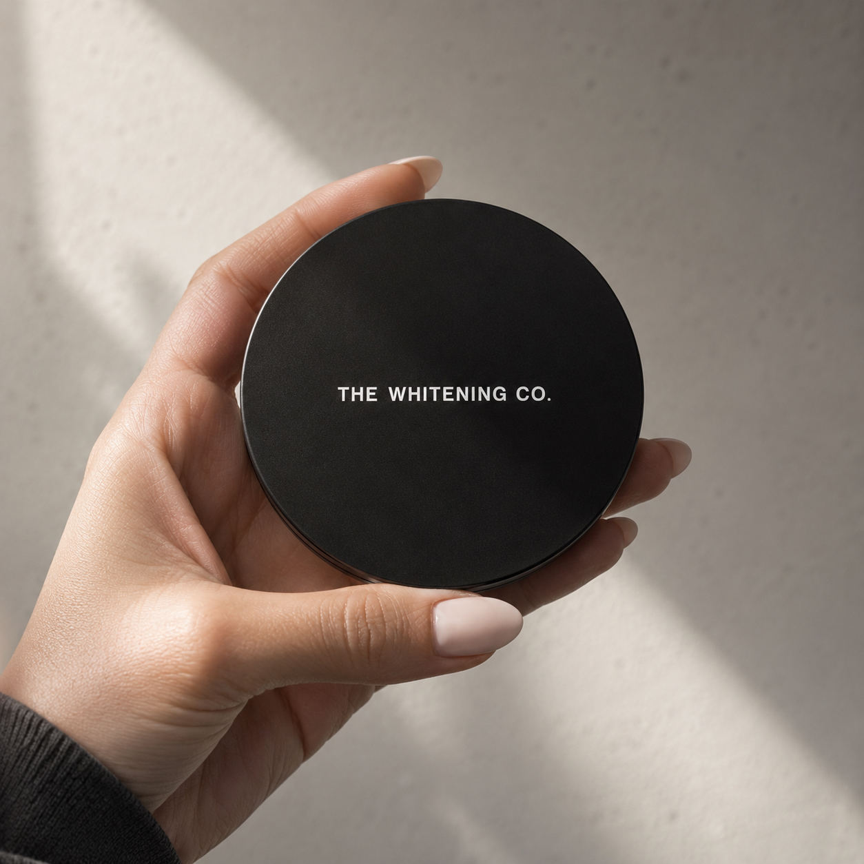 TWC LED E-Mirror closed, held in hand showing compact size and matte black finish